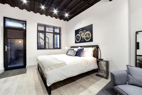 a bedroom with a bed with a bicycle picture on the wall at Modern Luxury Studios London in London