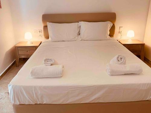 1 dormitorio con 1 cama con 2 toallas en Nine Muses Villas - Clio Terpischori en Hersonissos