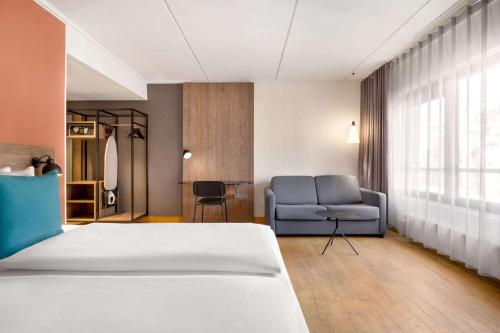 a hotel room with a bed and a chair at Comwell H C Andersen Dolce by Wyndham in Odense