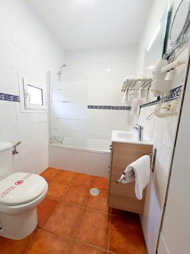 a bathroom with a toilet and a sink and a tub at Zaida Boutique Hotel in Seville