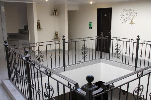 a staircase with a black railing and a black door at Hoteles Bogotá Inn Santa Bárbara Usaquén in Bogotá