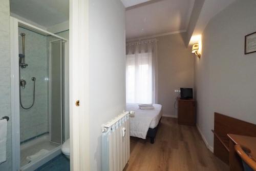 a bathroom with a shower and a bed in a room at Hotel Laura in Rome