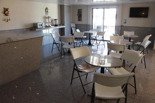 a restaurant with tables and chairs in a room at Hoteles Bogotá Inn Santa Bárbara Usaquén in Bogotá