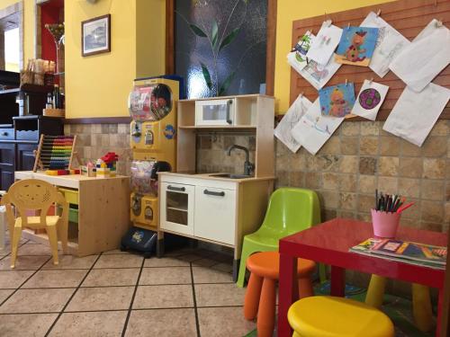 a toy kitchen with a counter and a table at Casa Merano Residence & Restaurant Bibione Centro in Bibione