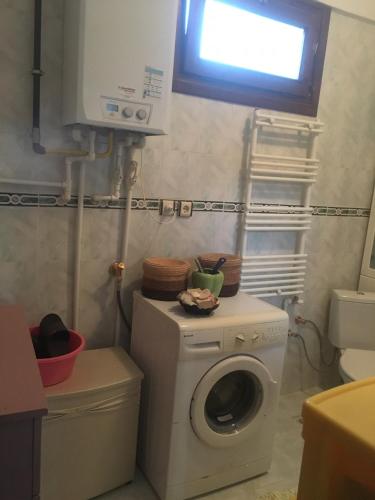 a laundry room with a washing machine and a window at Termal house in Termal