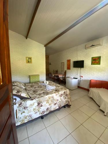 a hotel room with two beds and a television at La Dolce Vita in Mulungu