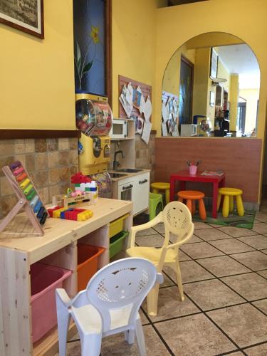 a kitchen with chairs and a table in a room at Casa Merano Residence & Restaurant Bibione Centro in Bibione