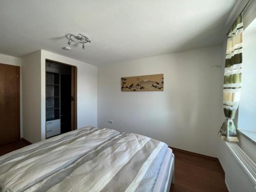 a white bedroom with a bed and a window at Ferienwohnung Haus Brenner in Seeg