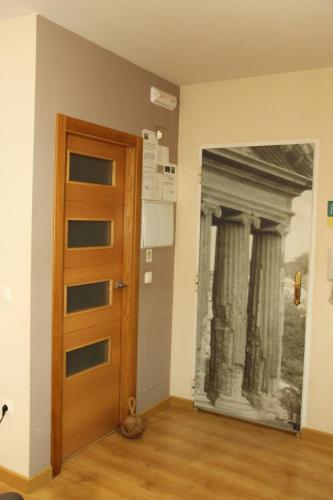 a door in a room with a painting on the wall at Apartamentos Alcazar de Baeza in Baeza