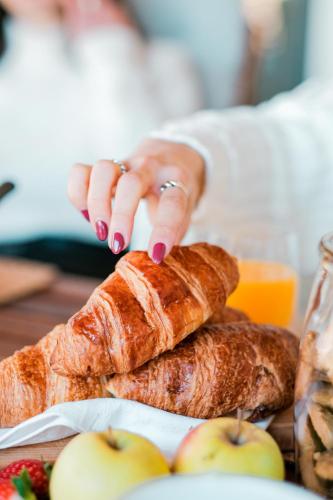 a woman is reaching for a loaf of bread on a table at Casa das Letras - Turismo rural in Ponte da Barca