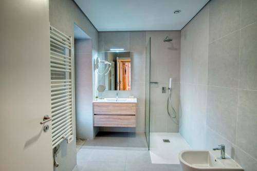 a bathroom with a sink and a shower and a mirror at Casa das Letras - Turismo rural in Ponte da Barca