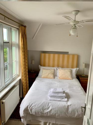 a bedroom with a white bed with towels on it at Parsnips House BnB Glastonbury in Glastonbury