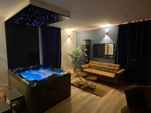 uma sala de estar com um sofá e uma grande banheira em Le privilège spa em Langeais