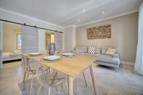 une salle à manger avec une table et un canapé dans l'établissement IMMOGROOM- Apartment 70m2 - Renovated - Wifi - AC - Close to everything, à Cannes