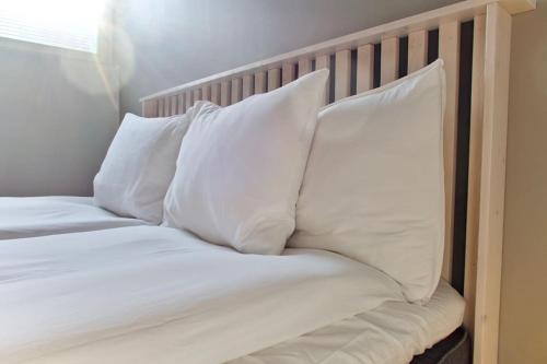 a bed with white sheets and pillows on it at Raikas 2021 paritalo keskustassa, Sauna, P-paikka in Tampere