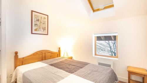 Schlafzimmer mit einem Bett und einem Fenster in der Unterkunft Les Marmottes - 42 - Appart renove - 6 pers in Saint-Sorlin-dʼArves