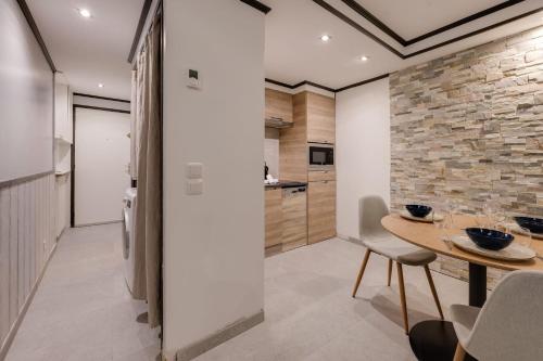 - une cuisine avec une table et un mur en pierre dans l'établissement Chaleureux plein centre ville et proche du Lac, à Annecy