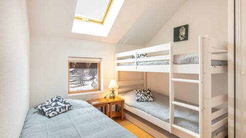 a bedroom with two bunk beds and a window at Les Marmottes - 40 - Appart confort - 7 pers in Saint-Sorlin-dʼArves