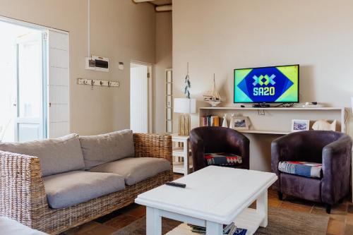 a living room with a couch and two chairs and a tv at Twalap in Paternoster