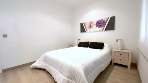 a white bedroom with a bed and a night stand at Rhode 1b in Roses