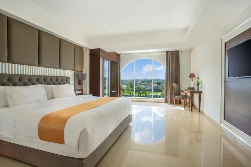 een slaapkamer met een groot bed en een groot raam bij Grand Rohan Jogja in Yogyakarta