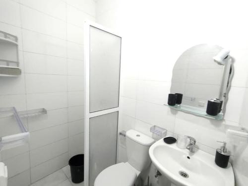 um banheiro branco com um vaso sanitário e uma pia em City Centre Apartment - New Deco em Tânger