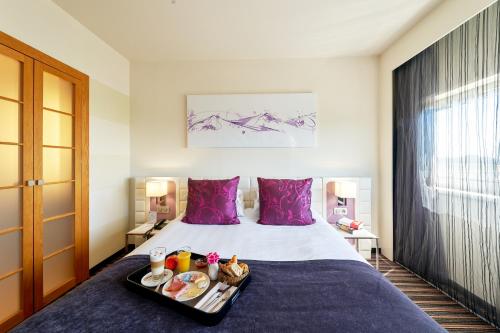 - une chambre d'hôtel avec un lit et un plateau de nourriture dans l'établissement Best Western Plus Hôtel Le Rhénan & Restaurant Chez Claude, à Dorlisheim