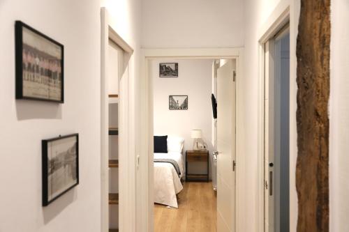 un couloir menant à une chambre avec un lit dans l'établissement Piso Moderno a 2 minutos del Casco Viejo con Parking Gratis, à Bilbao