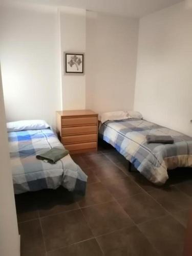a bedroom with two beds and a wooden dresser at Apartamento Pepe in Alcantarilla