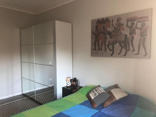 ローマにあるBoutique Apartment in Flaminio Areaのベッドルーム1室(ベッド1台付)が備わります。壁には絵画が飾られています。
