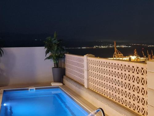a swimming pool on the balcony of a building at night at VILA ME in Eilat