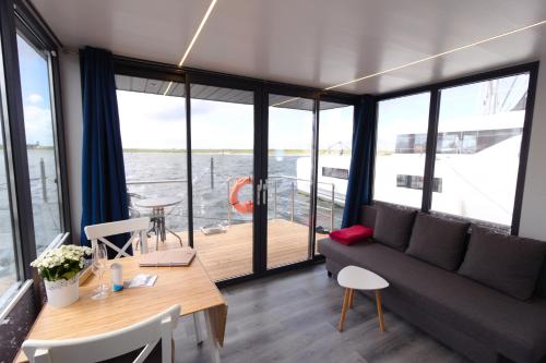 a living room with a couch and a table at Hausboot Fjord Aquila mit Dachterrasse in Wendtorf in Wendtorf