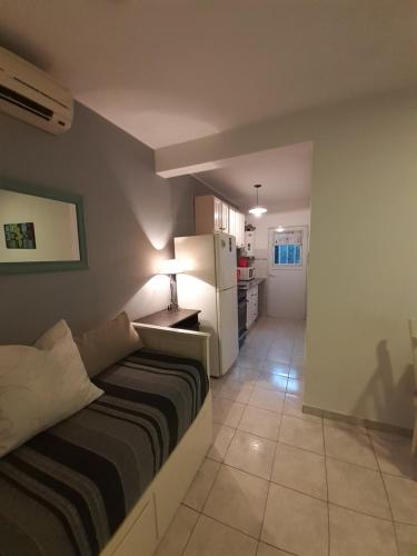 a room with a bed and a kitchen with a refrigerator at TEMPORARIO VM in Villa María