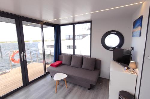 a living room with a couch and a balcony at Hausboot Fjord Aquila mit Dachterrasse in Wendtorf in Wendtorf