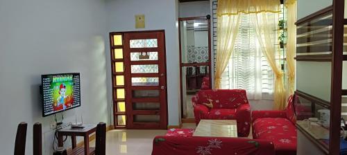 ein Wohnzimmer mit einem roten Stuhl und einer Tür in der Unterkunft Tourist and Transient HOME. in Sorsogon