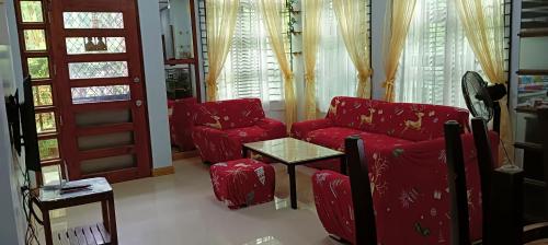 een woonkamer met rode banken en een tafel bij Tourist and Transient HOME. in Sorsogon