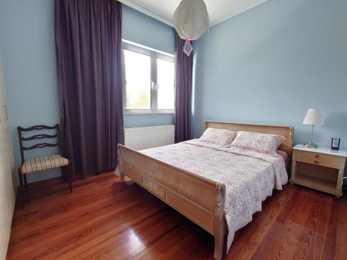 a bedroom with a bed and a chair and a window at Greek Aesthetic Manor House in Nea Makri