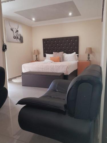 una camera da letto con un letto grande e una sedia di Apple Guesthouse a Lothlekane