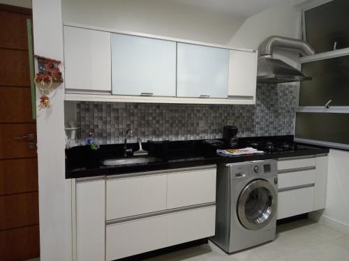 cocina con armarios blancos y lavadora en Copacabana Beach Modern Apartments, en Río de Janeiro