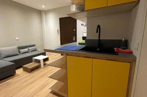 a kitchen with a yellow island in a living room at Athenian Aura Kolonaki - Feel Athens City Center in Athens