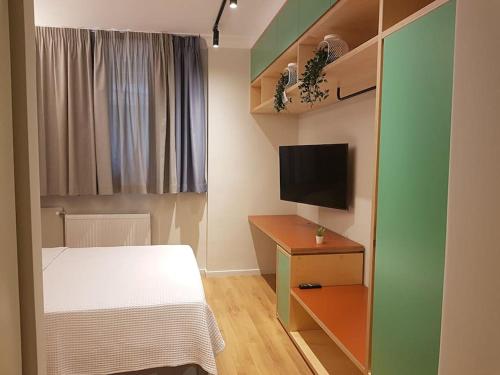 niewielka sypialnia z łóżkiem i telewizorem w obiekcie Athenian Aura Kolonaki - Feel Athens City Center w Atenach