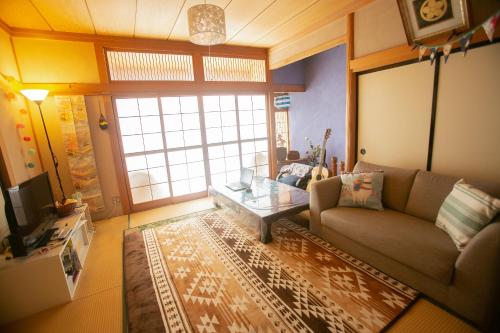 鹿角市にあるMinpaku AMBO - Friendly share house -のソファとコーヒーテーブルのあるリビングルーム