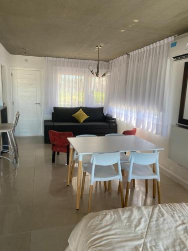 een woonkamer met een tafel en stoelen en een bank bij Linda Bay Beach & Resort Studio 304 in Mar de las Pampas