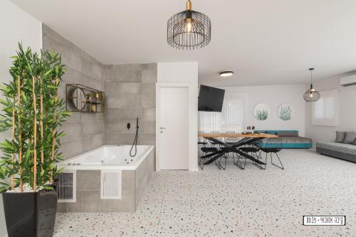 a living room with a tub and a dining room at Atnachta BaGilboa in Addirim