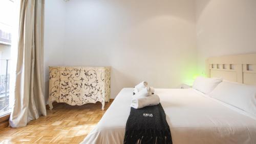 ein Schlafzimmer mit einem weißen Bett und einem Handtuch darauf in der Unterkunft Los Balcones de Maritxu in Toledo