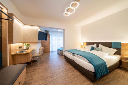 a hotel room with a bed and a desk at Hotel Trattnig in Döbriach