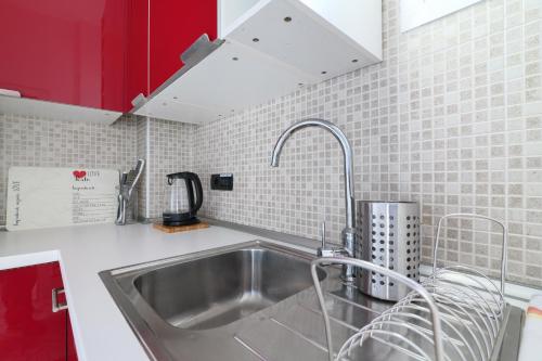 a kitchen with a sink and red cabinets at PrimoPiano - Baldinucci in Milan