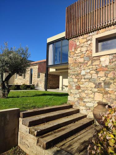a stone house with a staircase leading up to it at Raízes Turismo Rural in Castelo Branco