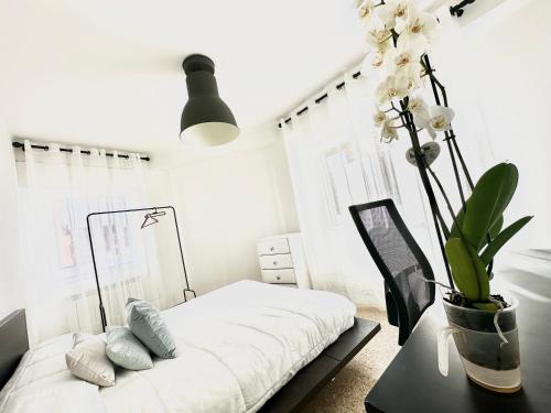 ein Schlafzimmer mit einem Bett und einem Tisch mit Blumen in der Unterkunft Apartamento Cebra in Saragossa