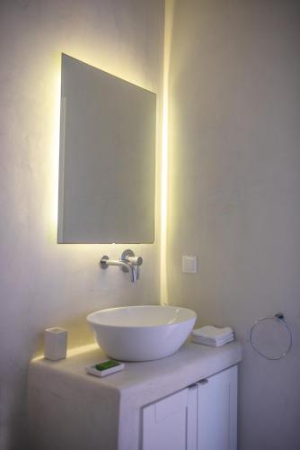 a bathroom with a white sink and a mirror at Theros apartments 1 in Mylopotas